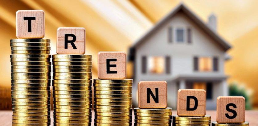 coins stacked in descending order with blocks resting on the top spelling trends with a house in the background