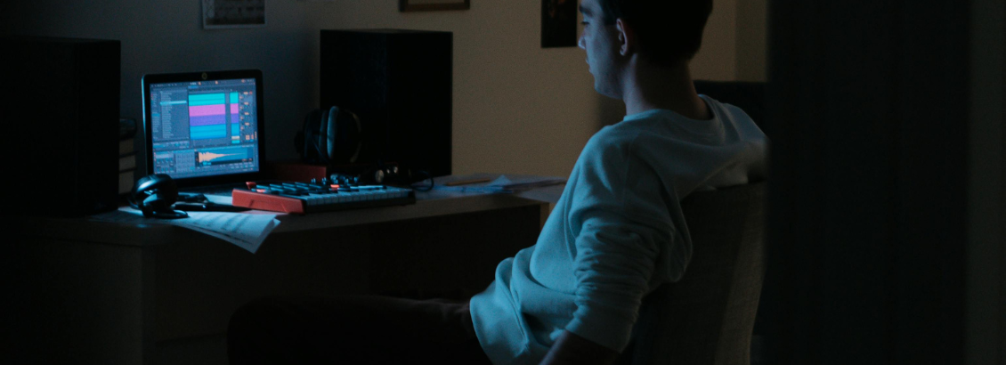 a worker working on a computer on his desk with hands hanging on the chair