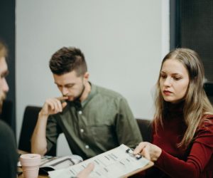 a group of three people working on a brand project approval of a brand discussion