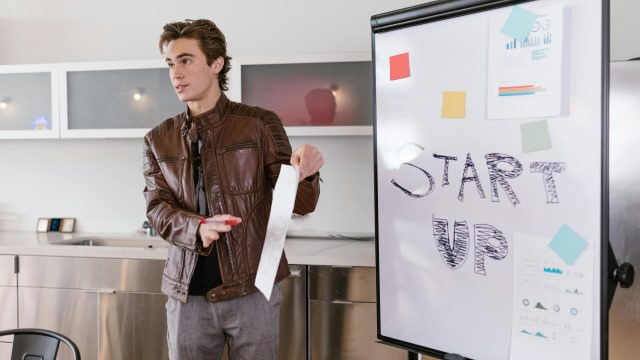 a man explaining a startup business idea with a vision board